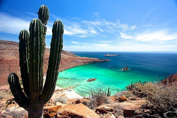 A bay on Espíritu Santo Island with mountains, cacti and turquoise water